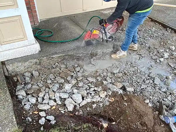 Worker cutting an old, cracked driveway